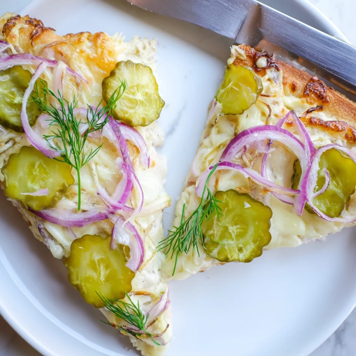 Tangy Pickle Pizza topped with creamy sauce, mozzarella, and crunchy dill pickles.  