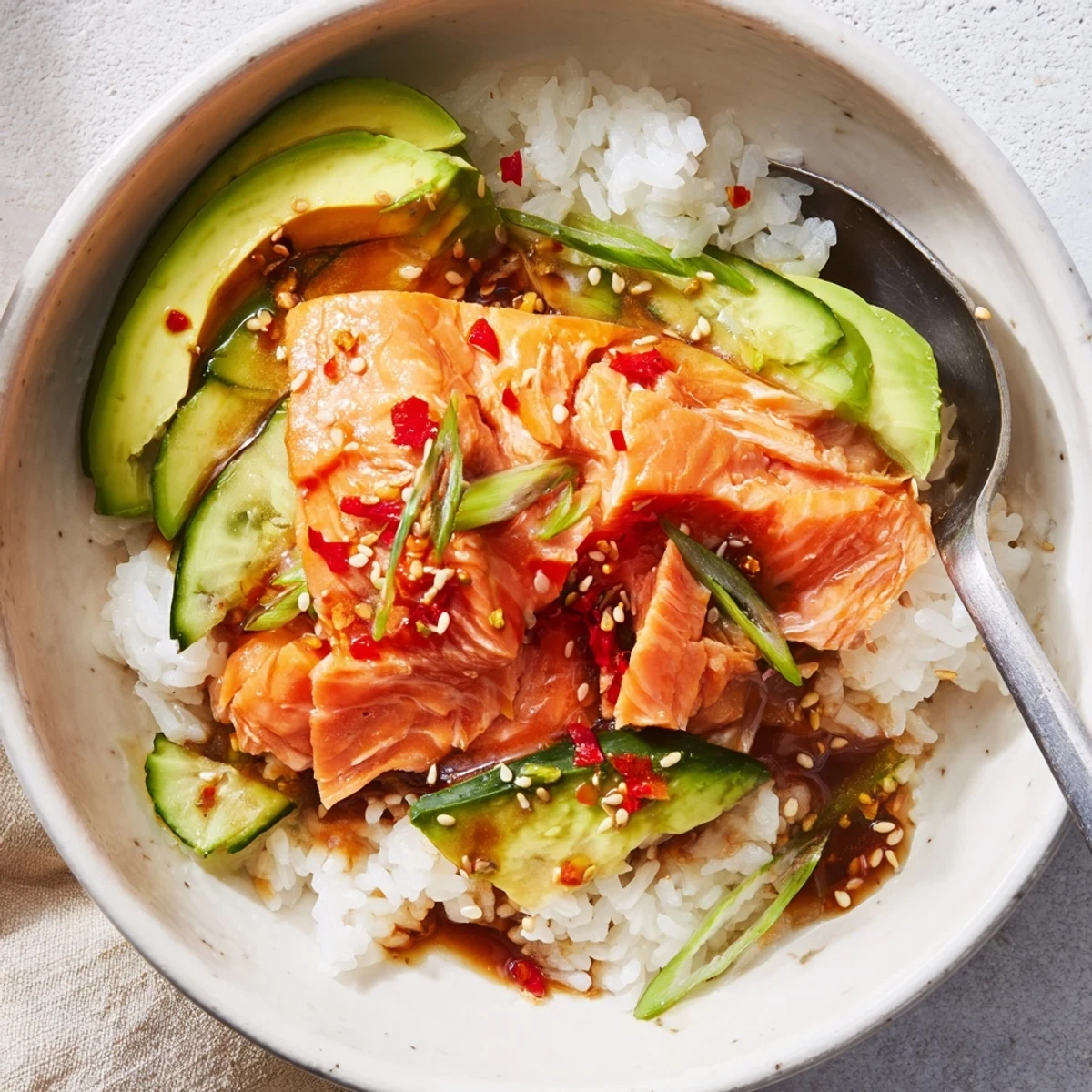 Delicious leftover salmon and rice bowl topped with fresh avocado and sesame seeds.  