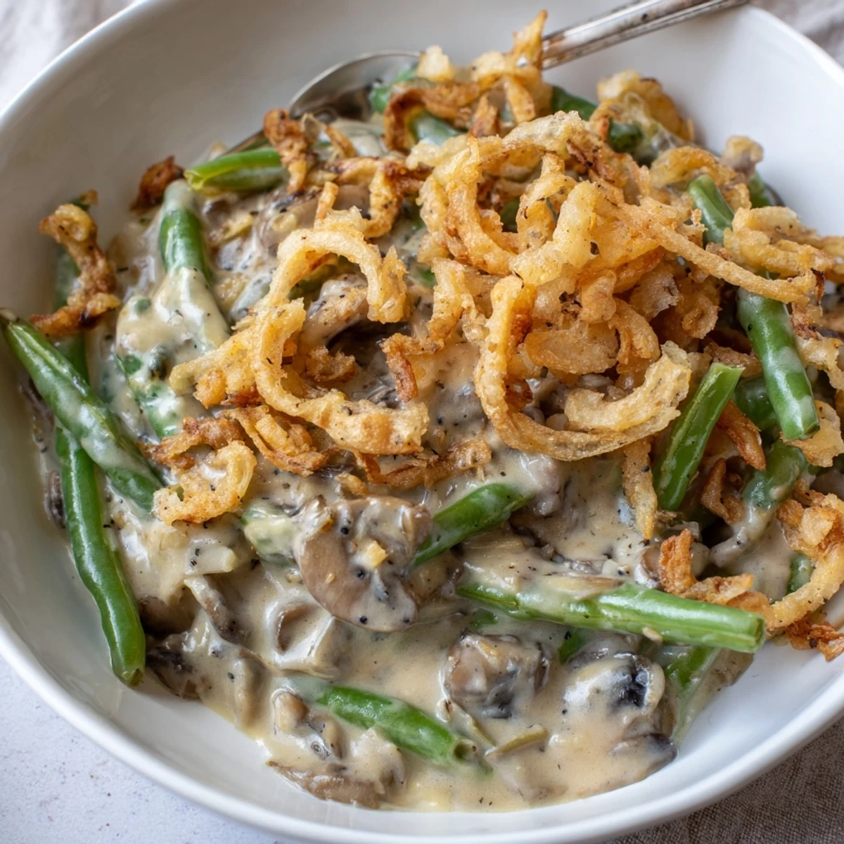 Creamy old-school green bean casserole topped with crispy onions for holiday dinners.  