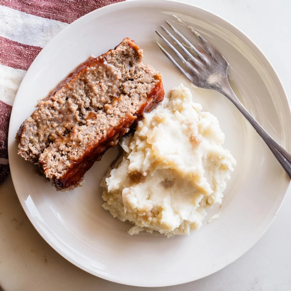 Tender Classic Meatloaf & Mashed Potatoes, steaming hot and ready to serve, a truly comforting meal.