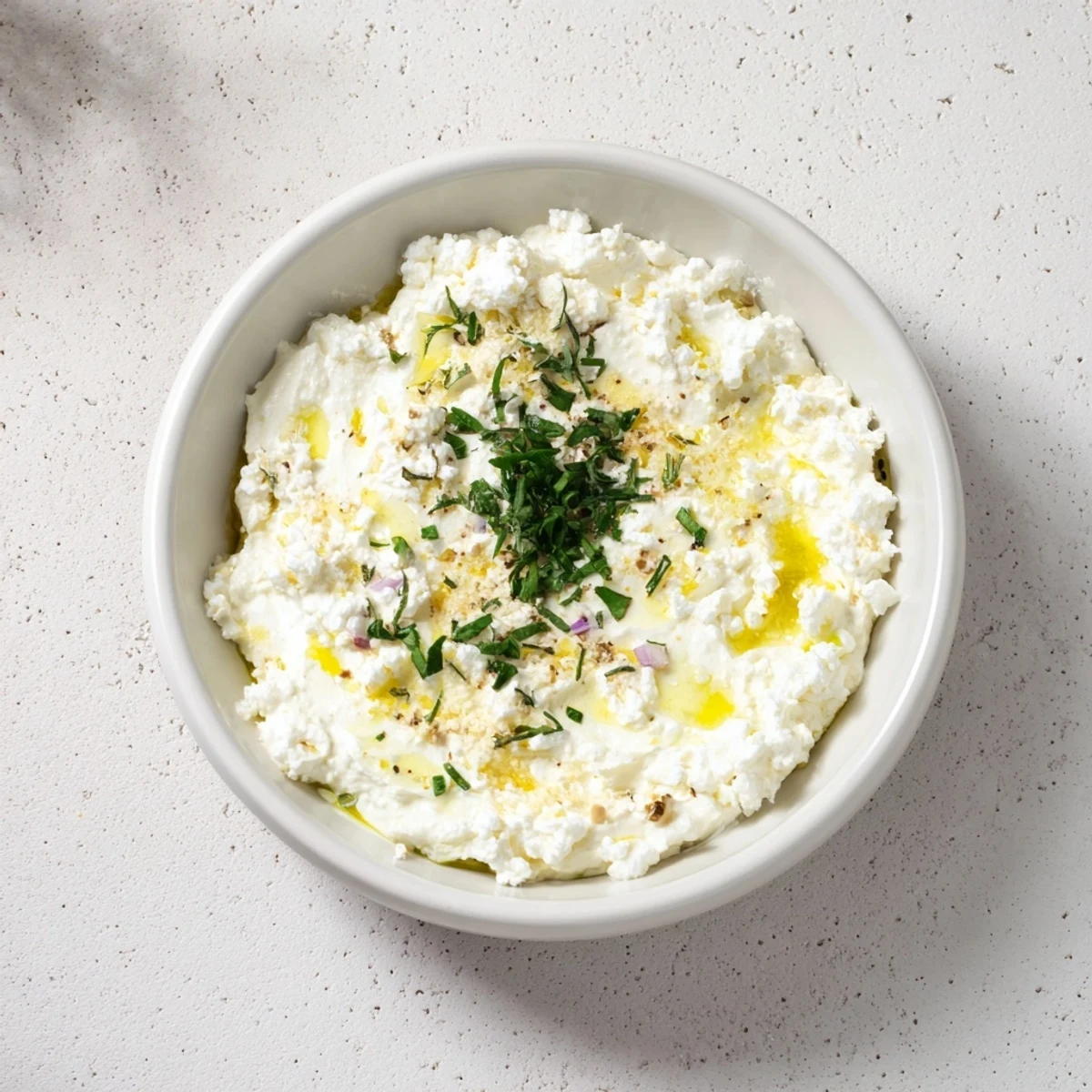 Creamy whipped feta dip with vibrant lemon-mint drizzle, ideal with pita bread.