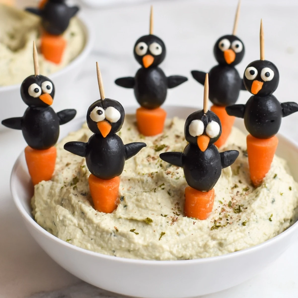 Mediterranean flavors abound in this flavorful Winter Dip, complete with cheerful olive penguin garnishes.