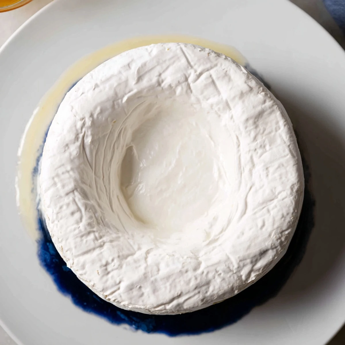 Floating Island appetizer: a creamy Brie cheese “island” floats on sapphire yogurt, surrounded by dark grapes.