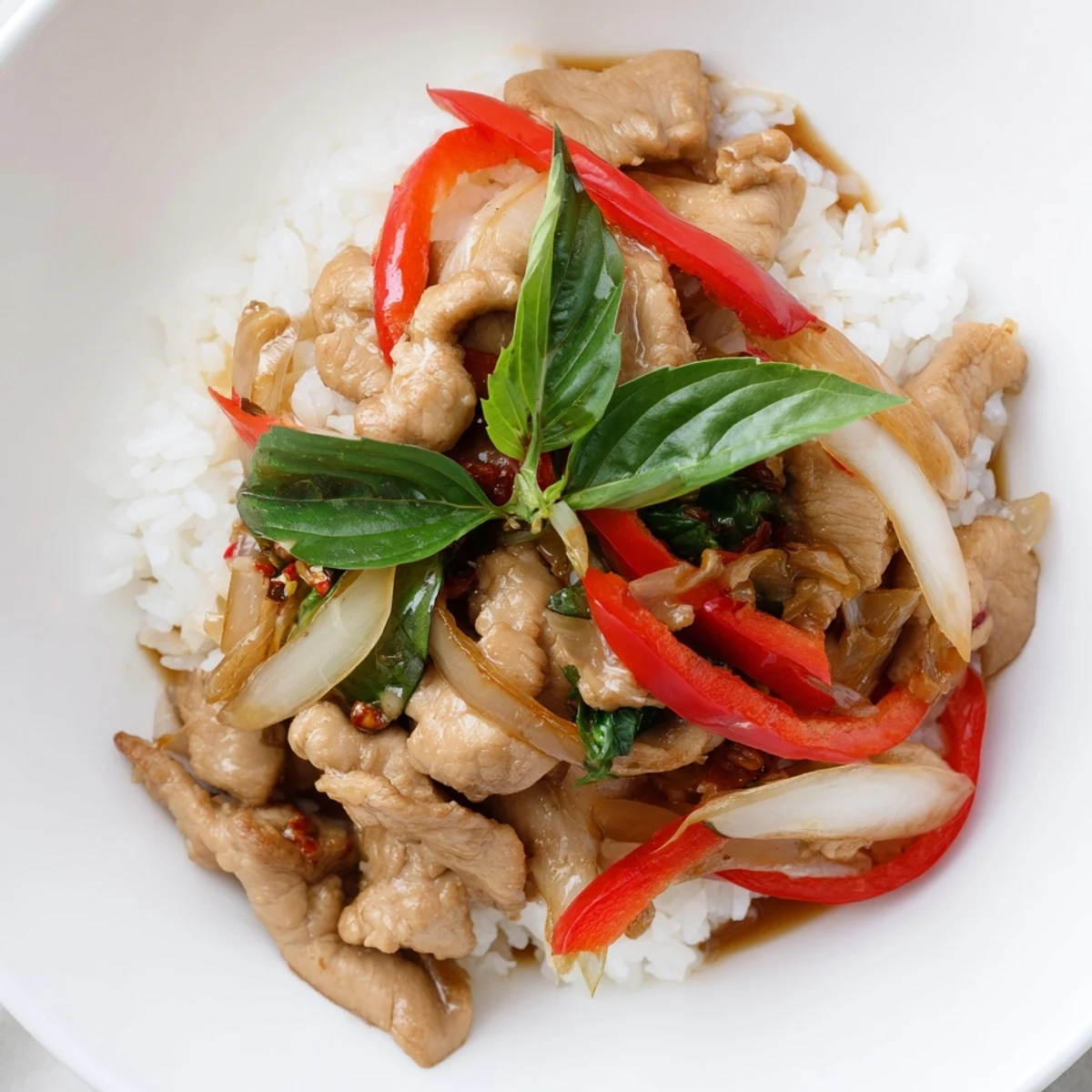 Steaming Thai Basil Chicken Bowls with fresh basil, tender chicken, and a savory sauce, ready to be enjoyed.