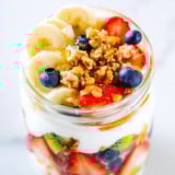 A bright Layered Yogurt Fruit Parfait reveals a layered cup of fresh fruit and Greek yogurt.
