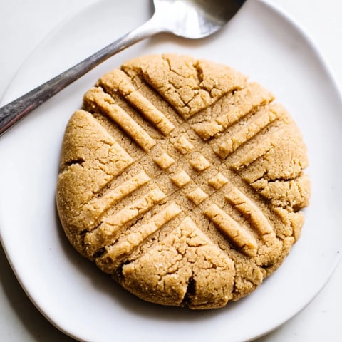 Warm, golden-brown flourless peanut butter cookies, arranged invitingly on a cooling rack for dessert.
