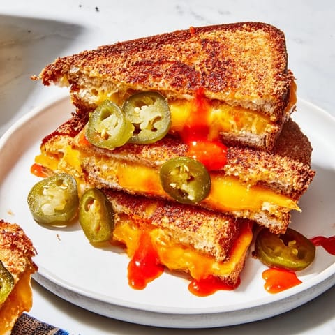 Close-up of crispy Spicy Pickle Grilled Cheese Dippers, with visible pickle slices, perfect finger food for sharing.