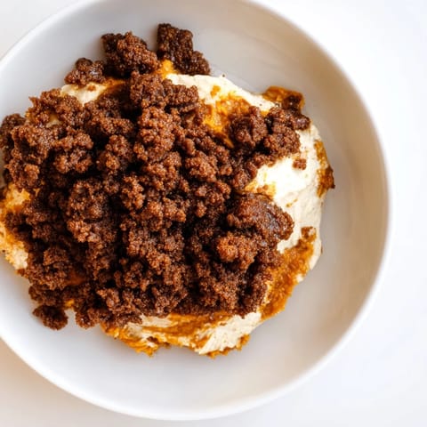 A warm, flavorful scoop of pumpkin crisp with a buttery crumble topping and spices.