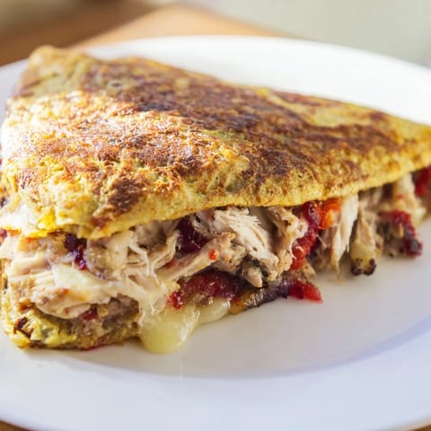 A close-up of a perfectly folded Turkey, Stuffing & Cranberry Leftovers Tortilla Wrap, ready to eat.