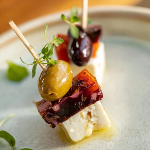 Mediterranean Holiday Cheers Olive and Feta Skewers, featuring bright red tomatoes and salty green olives, ideal for entertaining.