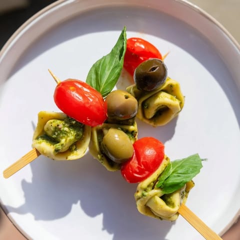 Vibrant Appetizer Skewers showcasing pesto-infused tortellini, olives, and cherry tomatoes, perfect for sharing.