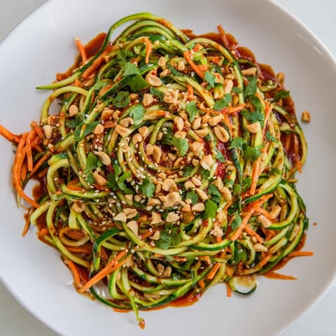 This Spicy Cucumber Noodle Bowl shows fresh, crunchy cucumbers coated in a vibrant, savory sauce just before serving.