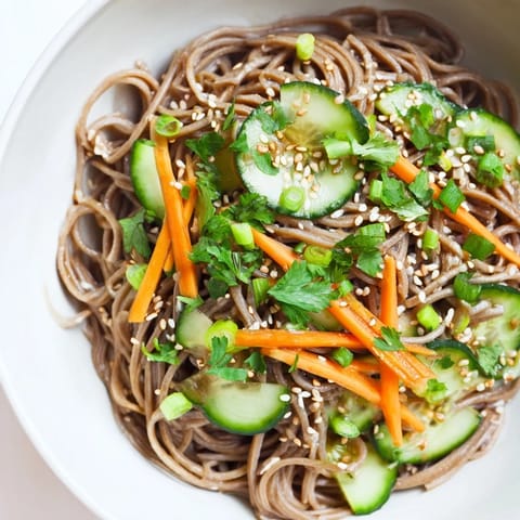 A close-up of savory Chilled Noodle Lunch Cups, featuring vibrant noodles with fresh cucumber & sesame seeds.