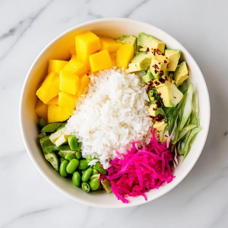 Close-up of pretty Mango Avocado Rice Bowl showcasing grains colorful veggies and zesty sauce.