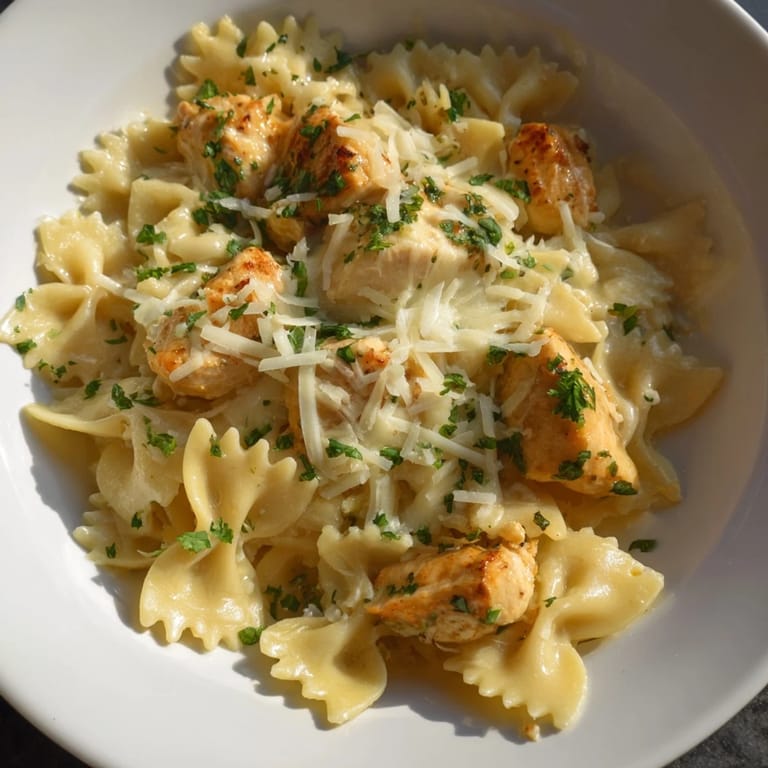 A comforting close-up showcases the bubbly mozzarella garlic butter chicken bowties, perfectly cooked and cheesy.