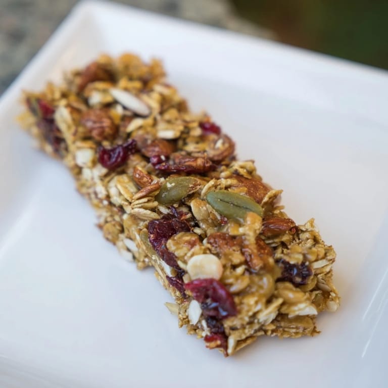 Close-up of freshly cut Roasted Pumpkin Seed & Cranberry Granola Bars, bursting with texture and flavor.