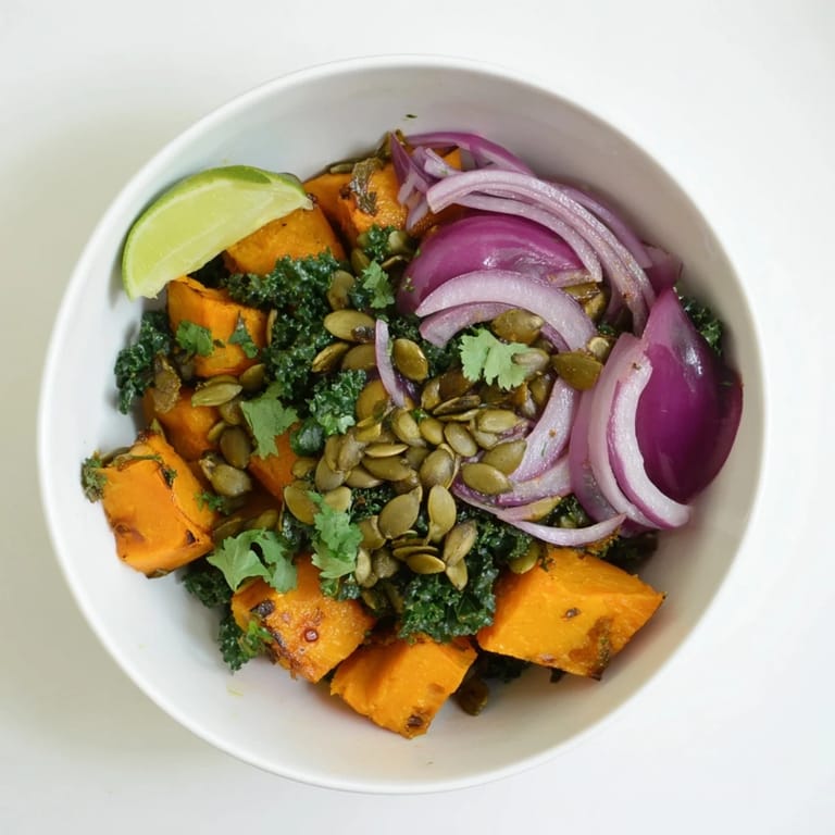 Sweet and Spicy Red Kuri Squash Bowl served over fluffy quinoa with wilted kale and lime wedges.