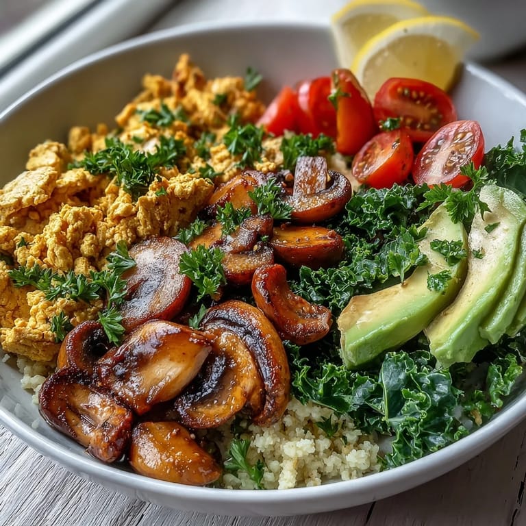 Golden turmeric tofu, garlicky mushrooms, and bright green kale top fluffy couscous in this easy vegan breakfast bowl.